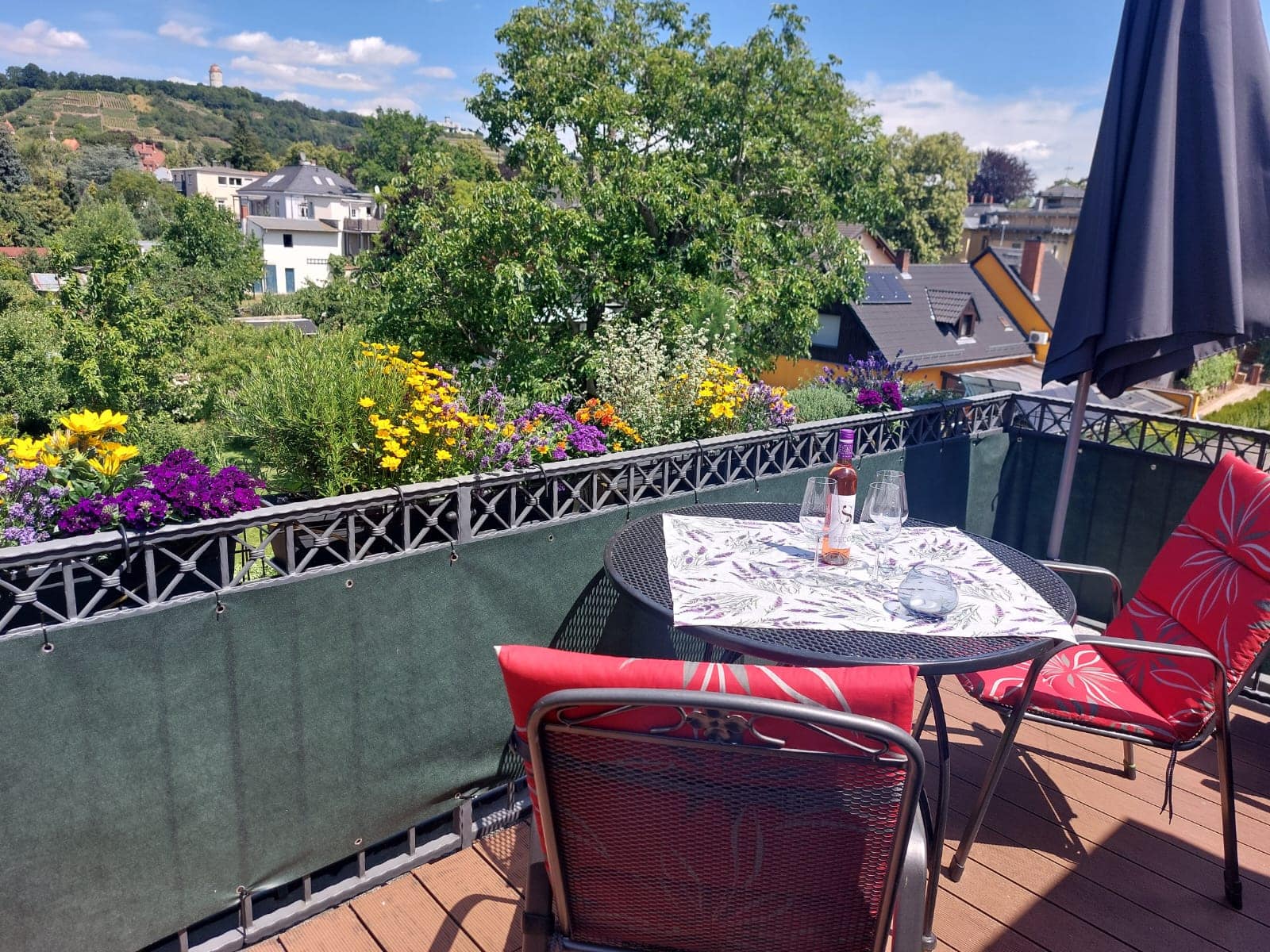 Balcony with table, vineyard view and parasol in the Wasserturm apartment